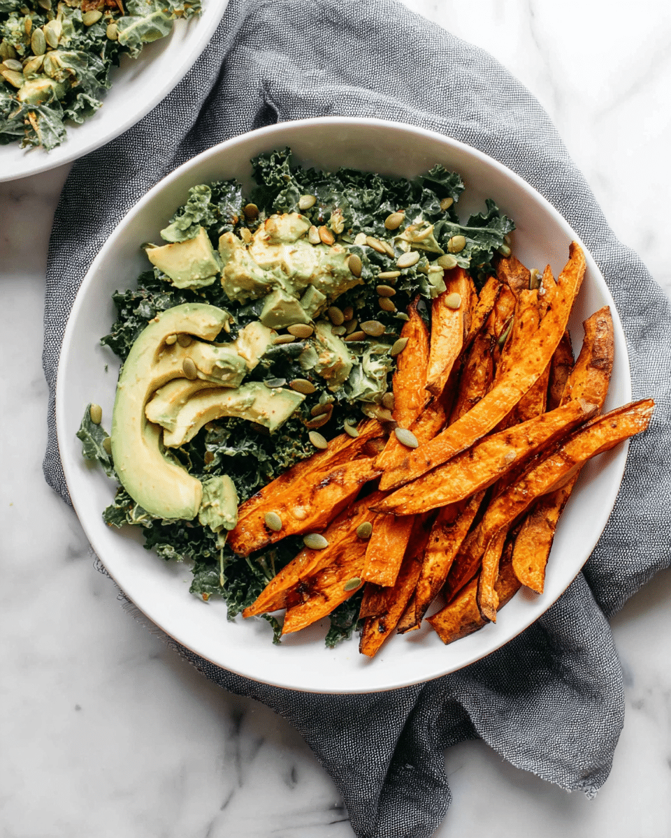 A white bowl holds a colorful dish with two parts: on the right, a pile of roasted sweet potato fries showing bright orange color with some charred edges and rough texture; on the left, a creamy kale salad with dark green leafy kale, chunks of light green avocado, and sprinkled pumpkin seeds adding small, round, light brown details. The bowl is placed on a slightly crumpled gray cloth on a white marbled surface. Photo taken with an iphone --ar 4:5 --v 7