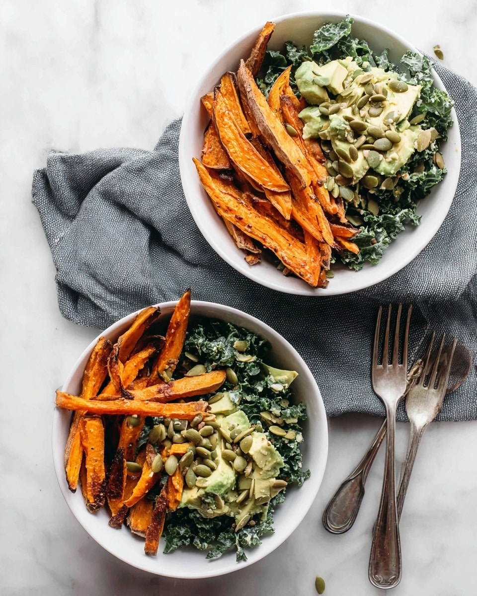 Two white bowls sit on a white marbled surface, each filled with two main layers. On one side of each bowl, there are bright orange sweet potato fries, slightly charred and crispy looking. On the other side, there is a green kale salad mixed with light green avocado chunks and topped with toasted pumpkin seeds. A gray cloth is folded beneath the bowls and two silver forks rest nearby. Photo taken with an iphone --ar 4:5 --v 7