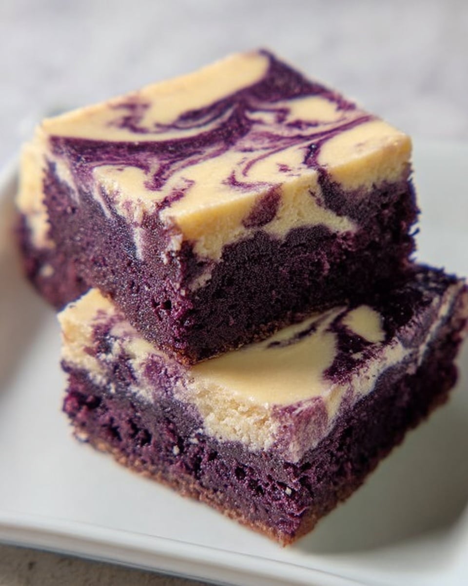 The image shows two square pieces of cake on a white plate placed on a white marbled surface. Each cake has two layers: the bottom layer is a rich, dark purple, moist and slightly crumbly texture, while the top layer is a creamy light beige with swirls of the same dark purple from the bottom layer, creating a marbled effect. The cakes are stacked so one leans on the other, showing the contrasting layers clearly. photo taken with an iphone --ar 4:5 --v 7