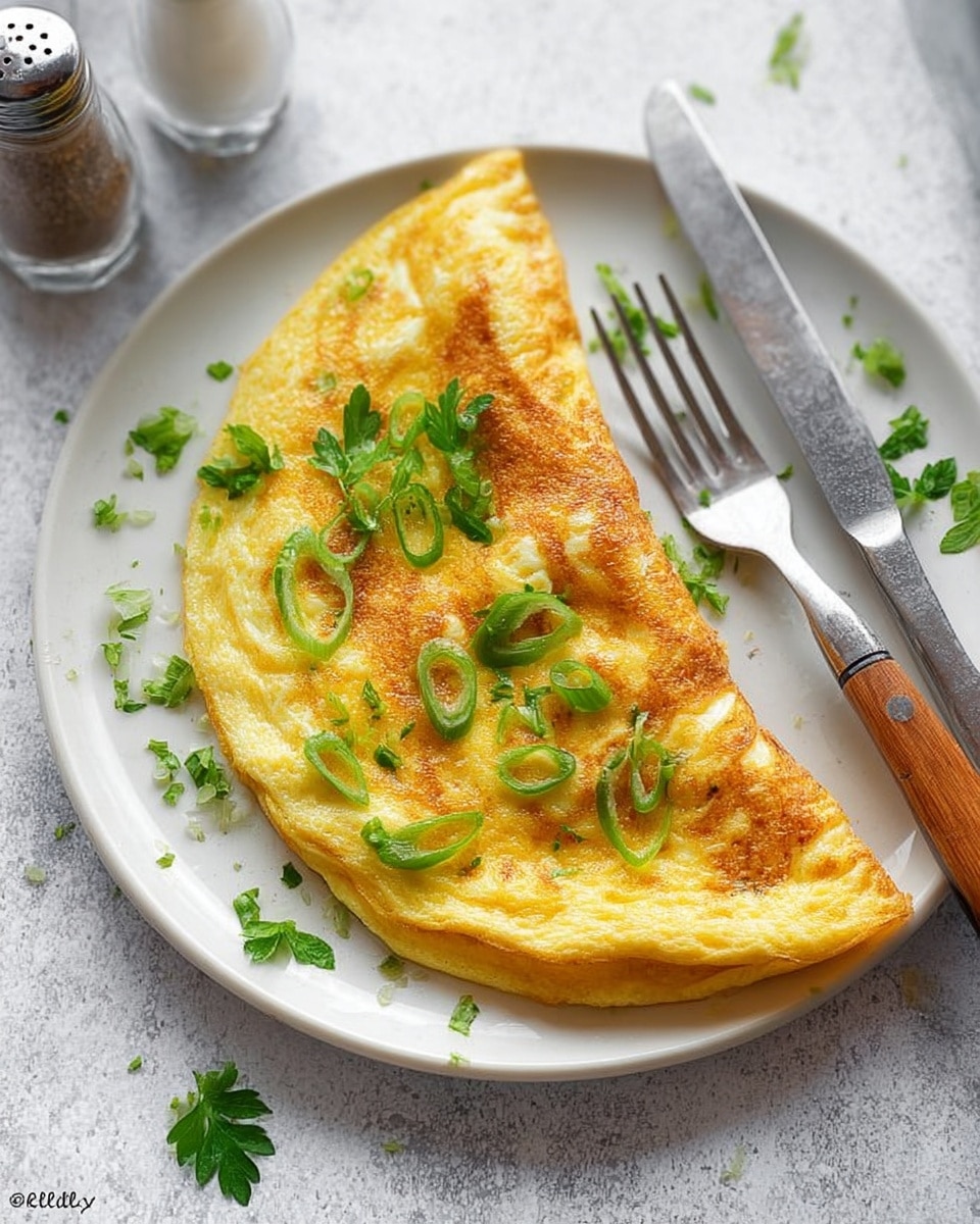 A single folded omelette with a golden-brown, slightly crispy surface, showing soft texture and slight bubbling, placed on a white round plate. The omelette has green slices of scallions and fresh flat-leaf parsley leaves scattered on top and around it. To the right of the omelette, a silver fork and a knife with a wooden handle rest on the plate. The plate is set on a white marbled textured surface, and in the upper left corner, a salt shaker and a pepper shaker are partially visible. photo taken with an iphone --ar 4:5 --v 7