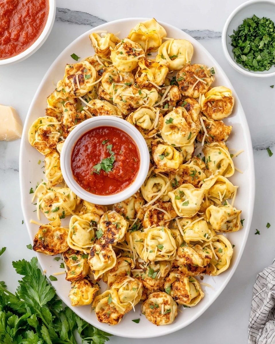 The image shows a white oval plate filled with golden-brown baked tortellini pasta, sprinkled with light grated cheese and small green parsley bits on top. In the center of the plate, there is a small white bowl of bright red marinara sauce with some green herb pieces floating on the surface. The plate is placed on a white marbled texture surface, surrounded by a small white bowl of chopped green herbs, some loose parsley leaves, and some grated cheese on a wooden plate. The scene also includes a piece of black and white striped cloth. photo taken with an iphone --ar 4:5 --v 7