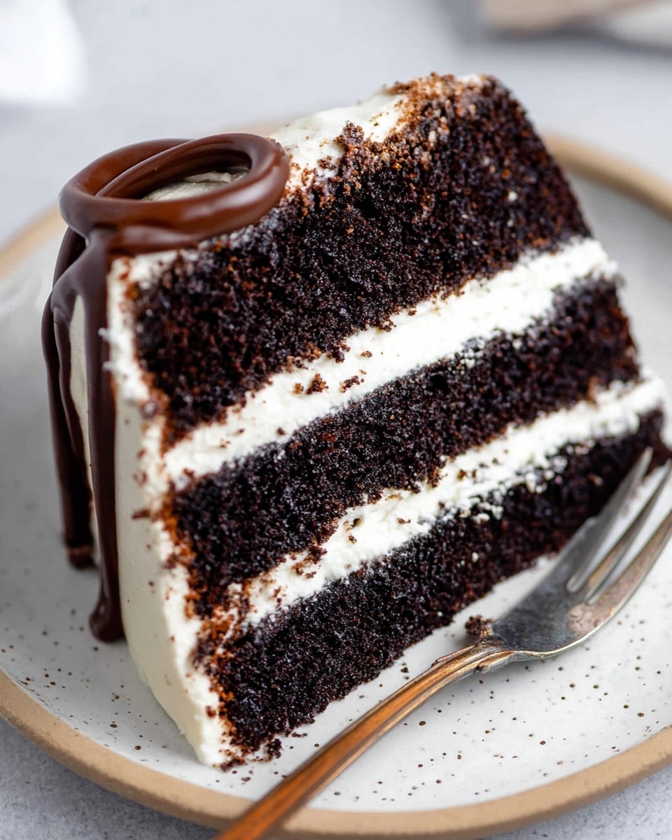 A close-up of a three-layer chocolate cake slice placed on a white plate with speckled detail, set against a white marbled texture. Each layer of the cake is dark, moist chocolate with a rough texture, separated by thick, even layers of smooth, white frosting. The cake is topped with a thick, glossy dark chocolate drizzle that partially covers the frosting on top. A fork rests on the right side of the plate, adding to the scene. Photo taken with an iphone --ar 4:5 --v 7