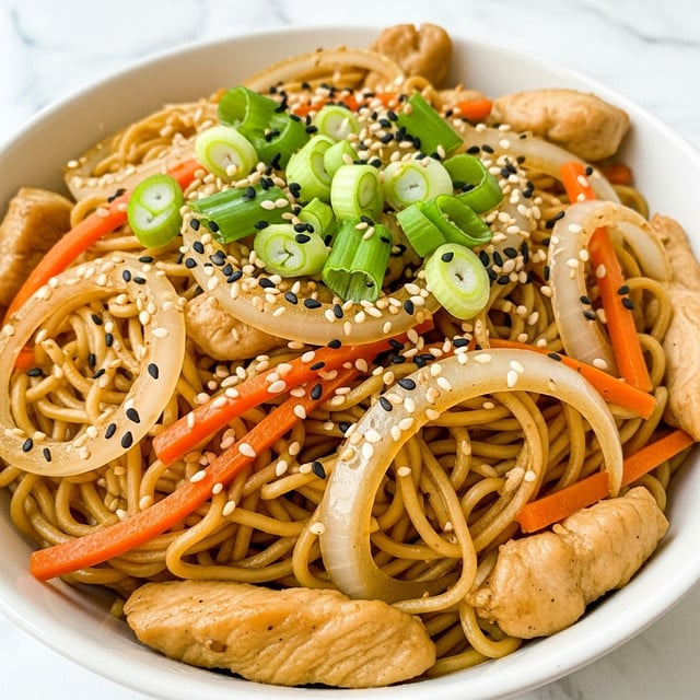 A white plate holds a serving of stir-fried noodles mixed with thin orange carrot strips, light green sliced scallions, and small pieces of light brown cooked chicken, all sprinkled with black and white sesame seeds on top. The noodles are pale yellow and glossy, showing a soft texture, with the vegetables and chicken mixed evenly throughout. Resting on the plate are a pair of wooden brown chopsticks, placed diagonally from the bottom left to the upper right. Above the plate is a black textured pan containing more noodles with visible bits of green onion and carrot, with a black utensil inside. To the right of the plate is a small light wooden bowl filled with black and white sesame seeds, some seeds scattered on a white marbled surface background. A beige textured cloth sits to the left. Photo taken with an iphone --ar 4:5 --v 7