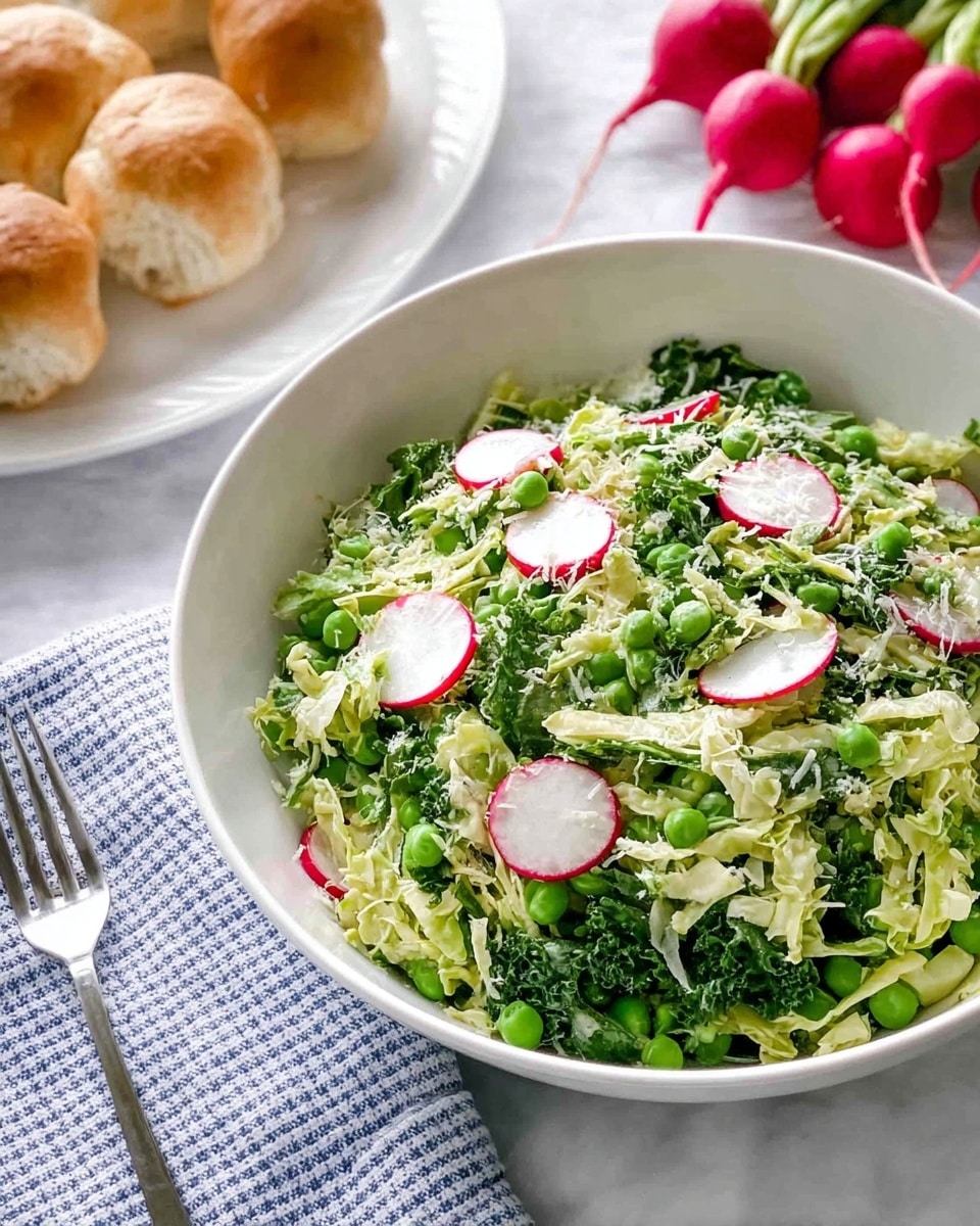 A white bowl filled with a salad made of green peas, shredded pale green cabbage, and bright green leafy herbs mixed together; thin, round slices of red and white radish are scattered throughout, adding a pop of color; the salad has a fresh and crunchy texture with a light sprinkling of grated cheese or small white seeds on top; in the background, a white plate holds small pieces of light brown bread rolls, three whole red radishes with green stems, and a silver fork rests nearby on a white and blue checkered linen; the surface beneath everything is a white marbled texture. photo taken with an iphone --ar 4:5 --v 7