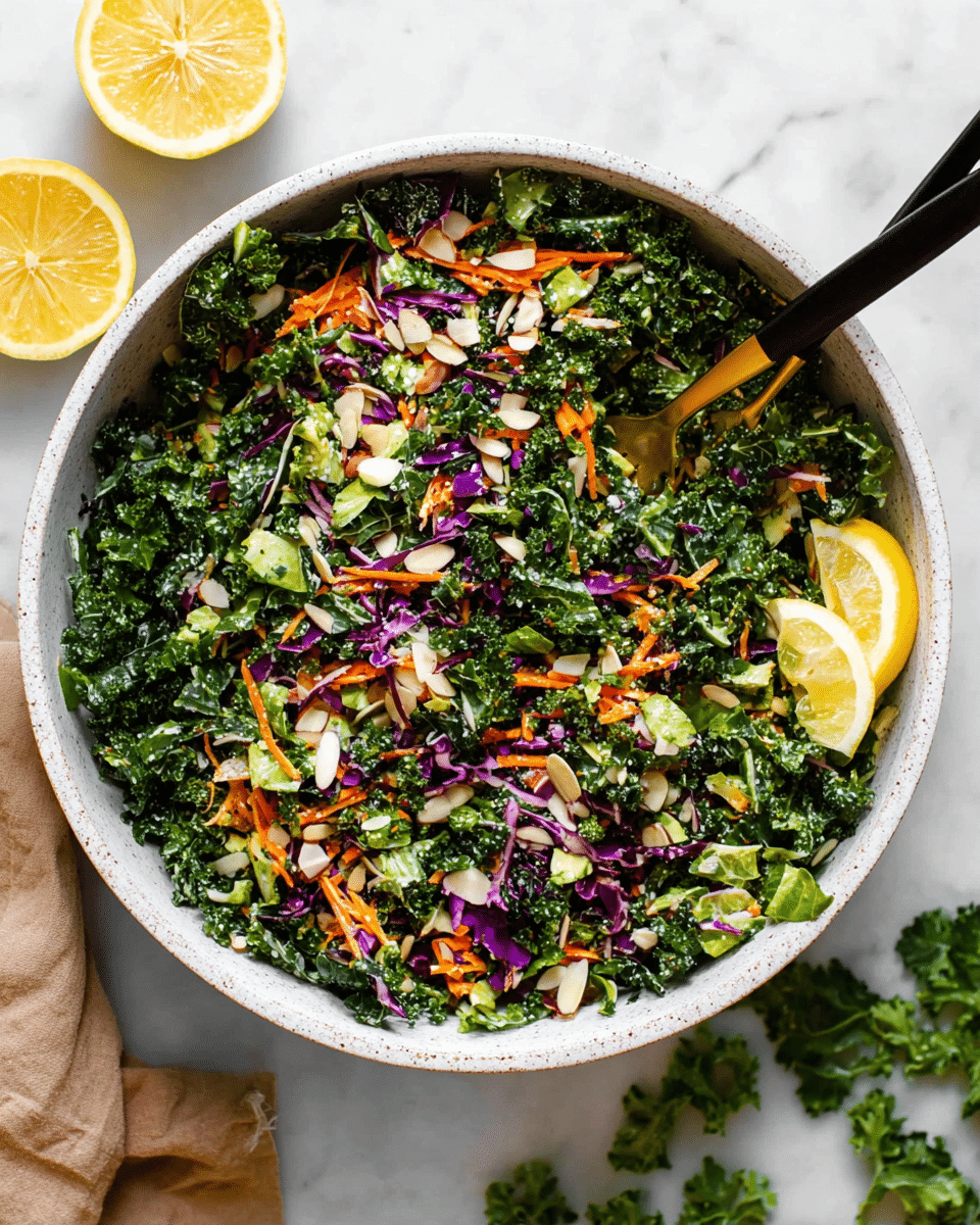 A large white bowl filled with a colorful chopped kale salad showing three main layers: the base layer is dark green kale leaves cut finely, the middle layer has bright orange shredded carrots and small pieces of purple cabbage, and the top layer is small green broccoli florets and pale almond slices scattered throughout. Two thin lemon slices rest on top on the right side, adding a touch of yellow. Two black and gold forks are partially buried in the salad, one on the left side and one on the bottom right. The bowl sits on a white marbled surface, with lemon halves and a small pile of green leaves nearby. photo taken with an iphone --ar 4:5 --v 7