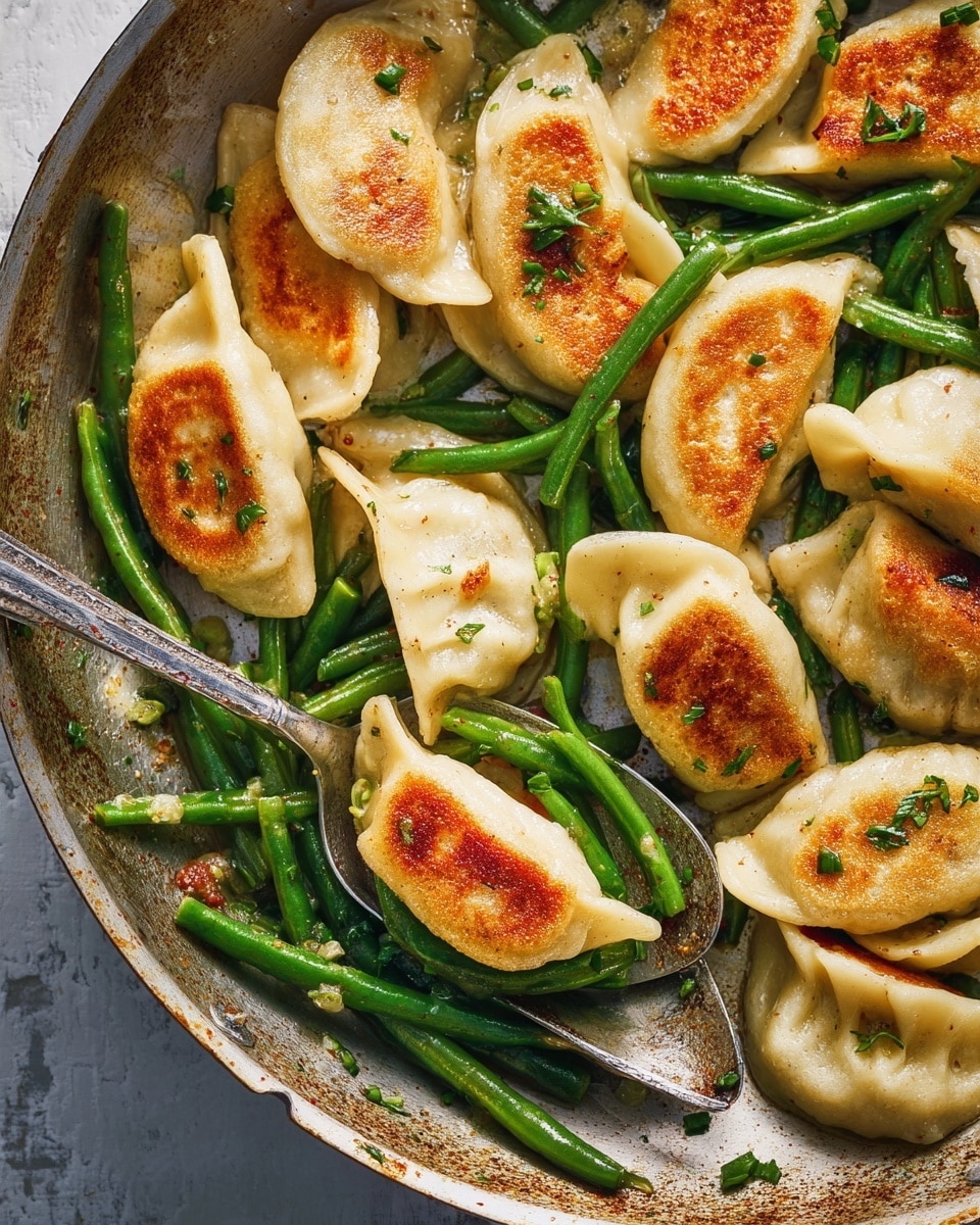 The image shows a pan filled with golden-brown pan-fried dumplings on top with a slightly crispy texture, mixed with bright green cut green beans that have a fresh and glossy look, and small bits of finely chopped green herbs scattered throughout. A large silver spoon holds one dumpling alongside two green beans, positioned on the right side of the pan. The dumplings are plump and crescent-shaped, with their light dough edges showing some soft folds. The whole dish sits on a background with a white marbled texture. photo taken with an iphone --ar 4:5 --v 7