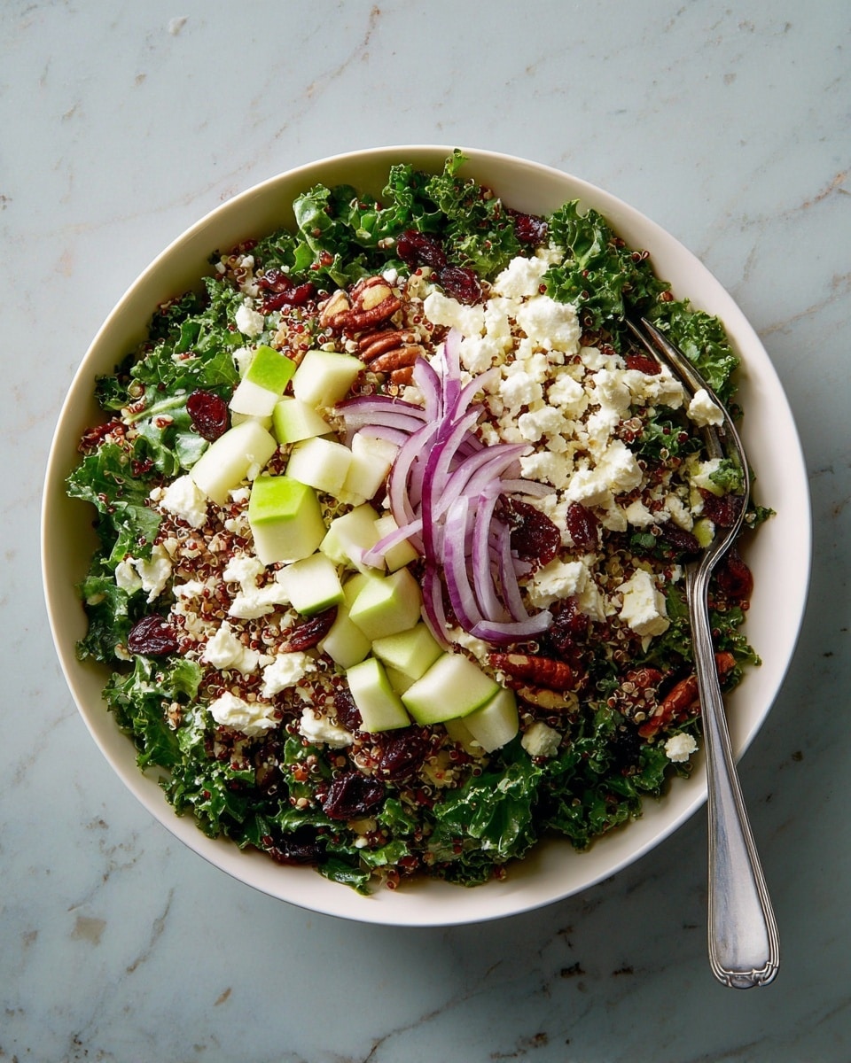 The image shows a white bowl filled with a layered salad on a white marbled surface. The first layer is a bed of dark green kale leaves, curly and fresh. The second layer contains light green diced apple chunks scattered evenly. On top of the apples are thin slices of purple-red onion, spread around. The next layer is made of small, fluffy white crumbles of cheese, distributed across the salad. Mixed in are cooked quinoa grains in shades of light brown and reddish-brown, adding a grainy texture. There are also deep red dried cranberries and glossy brown pecans scattered on the salad. A silver fork is placed inside the bowl on the right side. photo taken with an iphone --ar 4:5 --v 7